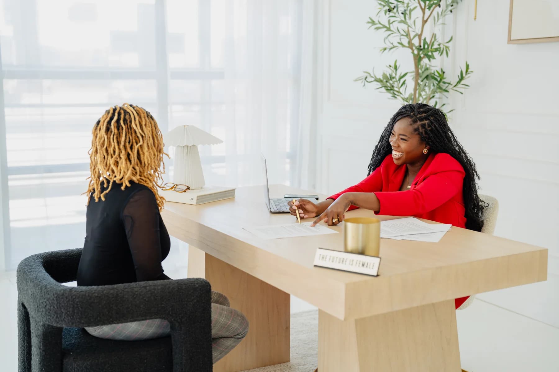 Vanessa smiling while coaching a client across a desk